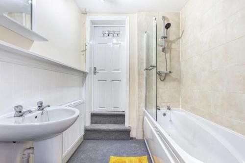 a bathroom with a sink and a tub and a toilet at Cloud View Cottage in Congleton