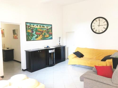 ein Wohnzimmer mit einem Sofa und einer Uhr an der Wand in der Unterkunft Casa Ada in Marina di Cecina