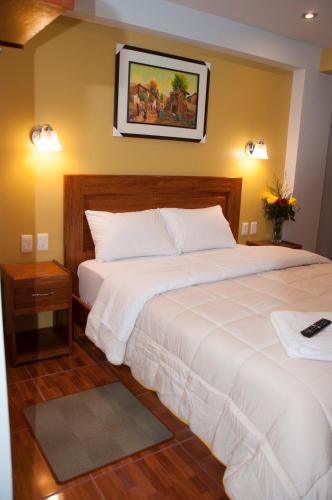 a bedroom with two beds and a picture on the wall at Picos House MachuPicchu in Machu Picchu