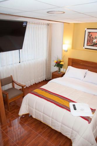 a hotel room with a bed and a tv at Picos House MachuPicchu in Machu Picchu