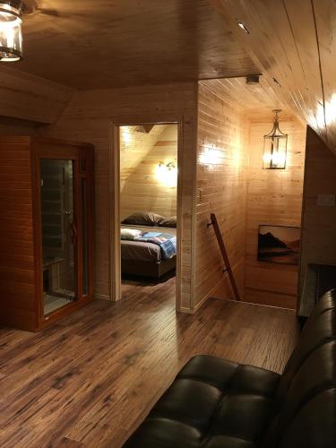 a room with a bed and a couch in a room at Sandy Shore Cottages Luxury Resort on Rice Lake in Harwood