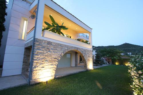 a house with an archway on the side of it at Aerides Luxury Villa in Paleo Tsifliki