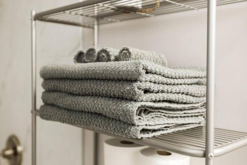 a bunch of towels on a rack in a bathroom at Modern Executive Suite I Complimentary Netflix & Parking! in Edmonton