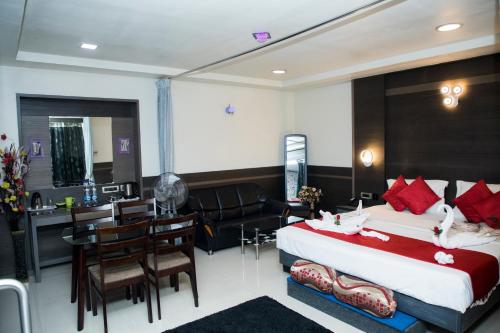 Habitación de hotel con cama y comedor en Moskva Hotel en Madurai