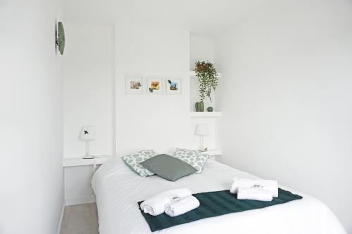 a white bedroom with a bed with towels on it at Mood Lodging - Caldas & Ocean in Óbidos