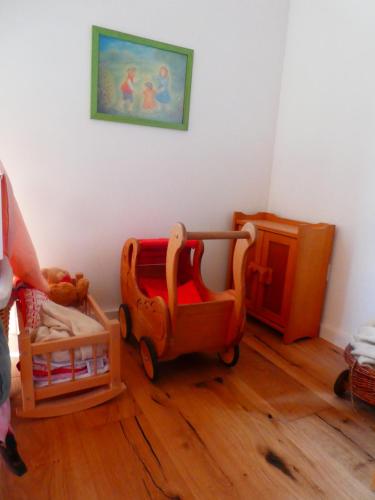 a childs room with a toy wagon and a crib at Ferienwohnung Bodensee Bullerbü in Eigeltingen