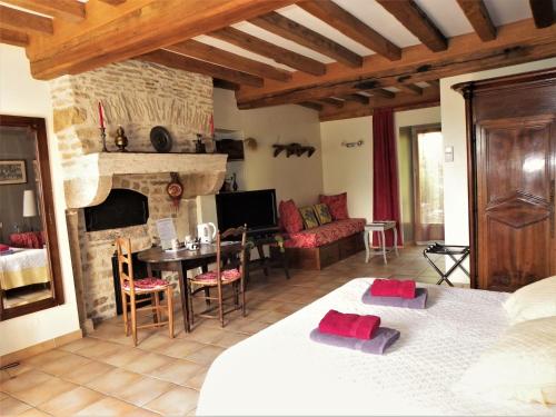 ein Schlafzimmer mit einem Bett und ein Wohnzimmer mit einem Kamin in der Unterkunft Le Cottage du Château in Chaudenay-le-Château