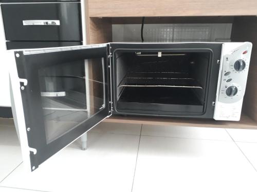 a microwave oven with its door open in a kitchen at 10 Studios in Sao Paulo