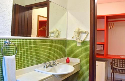 a bathroom with a sink and a mirror at Pousada Mais Bella in Ilhabela