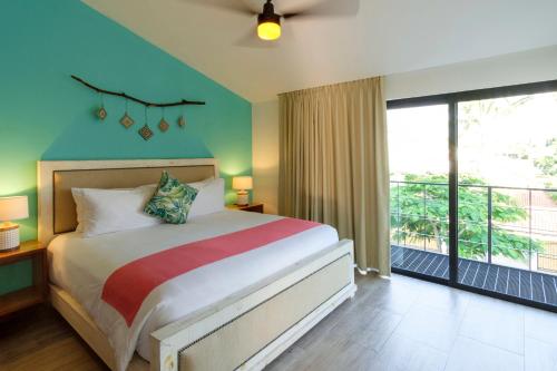 a bedroom with a bed and a balcony at San Trópico Boutique Hotel & Peaceful Escape in Puerto Vallarta