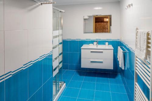 Baño azul con lavabo y espejo en CASA GOMARIS en Zas