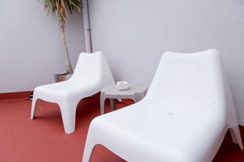 two white chairs and a table in a room at Hotel Marítimo Urban in Alicante