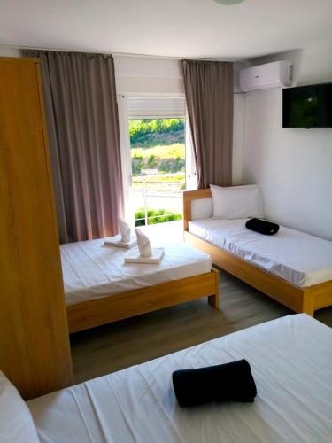 a hotel room with two beds and a window at Rosi`s Apartment in Sutomore