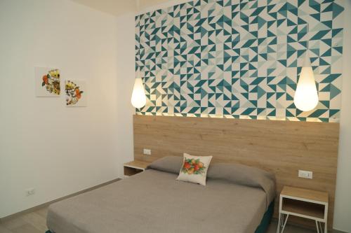 a bedroom with a bed and a geometric wall at Terra d'amare in Castelluzzo
