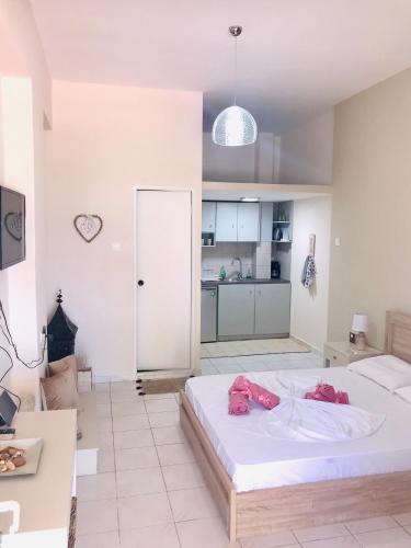 a bedroom with a large bed and a kitchen at Seaview Apartments in Anavissos