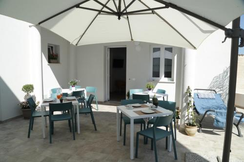 a patio with tables and chairs and an umbrella at Terra d'amare in Castelluzzo
