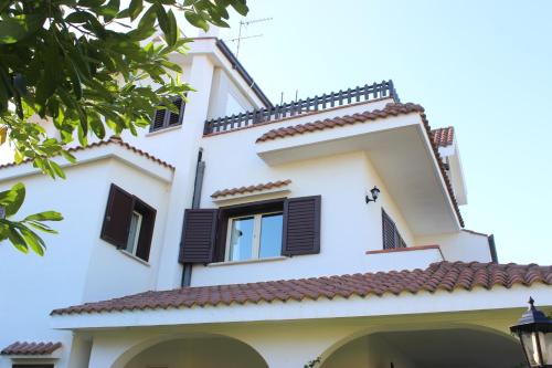 a white building with black shuttered windows at Domus Dams B&B in Montescaglioso