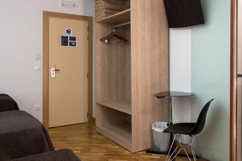a room with a closet with a chair and a table at Pensión Laurel in Logroño