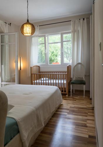 a bedroom with a bed and a crib and a window at Lovely apartm.near airport in Kardiá