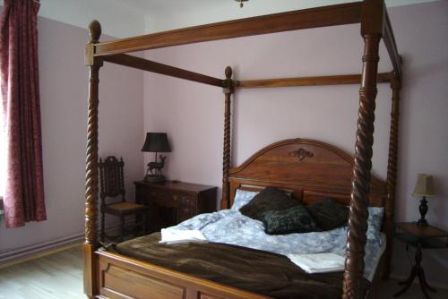 a bedroom with a wooden canopy bed with pillows at Nyx & Iris in Zasa