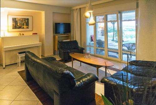 a living room with a couch and a table at Lovely apartm.near airport in Kardiá