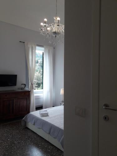 a bedroom with a bed with a chandelier and a window at DORA AUREA in Levanto