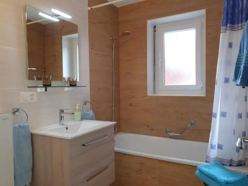 a bathroom with a sink and a tub and a shower at Apartments Weid in Leukerbad