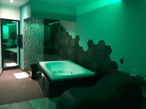 Intimisimo Suites Autohotel Centro Only Adult في فيراكروز: حمام مع حوض ومرآة كبيرة
