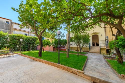 un cortile alberato e un edificio di Villa Valverde Apartments e B&B a Taormina