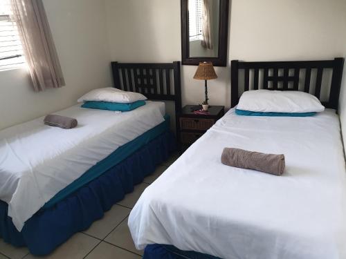 two beds sitting next to each other in a room at Uvongo Lucian Blue Flag Beach Apartment in Margate