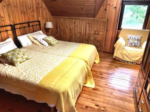 a bedroom with a bed and a chair in a room at FINCA SALVADOR in Baralla