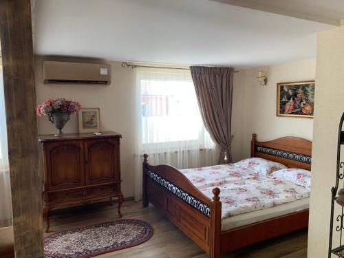 a bedroom with a bed with a dresser and a window at Arbatinės apartamentai in Biržai