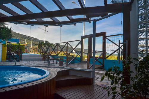 a hot tub on the deck of a building with a view at Residencial Vila do Sol, Apartamentos com pé na areia in Bombinhas