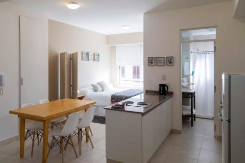 DEL SOL Apartamentos Salta في سالتا: مطبخ وغرفة معيشة مع طاولة وأريكة