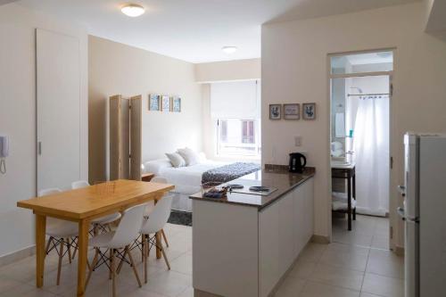 a kitchen and living room with a table and a couch at DEL SOL Apartamentos Salta in Salta