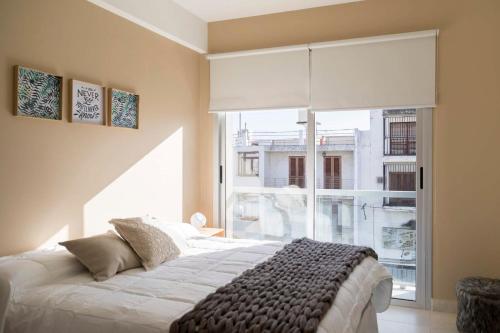 a bedroom with a bed and a large window at DEL SOL Apartamentos Salta in Salta