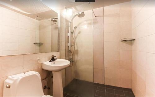 a bathroom with a toilet and a sink and a shower at Prince Hotel in Gwangju