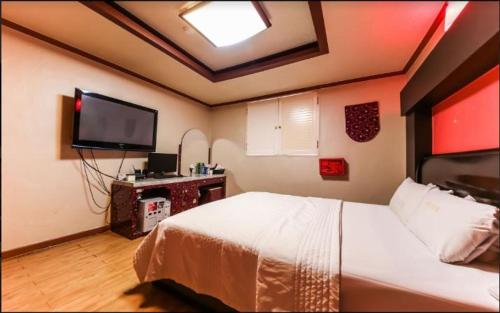 a bedroom with a bed and a flat screen tv at Prince Hotel in Gwangju