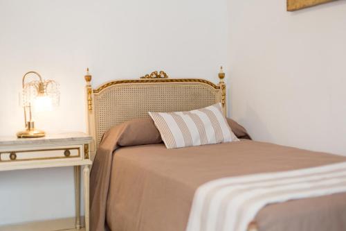 a bed with a pillow and a nightstand with a lamp at Hotel Marítimo Urban in Alicante