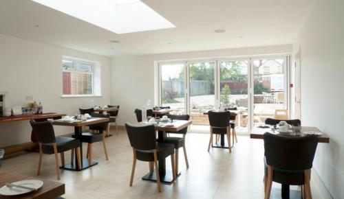a restaurant with tables and chairs in a room at Park Lodge in Farnborough