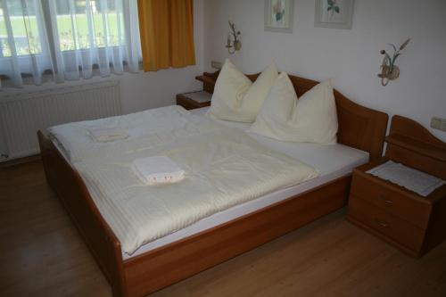 a bedroom with a bed with white sheets and pillows at Appartement Mayr in Kirchdorf in Tirol
