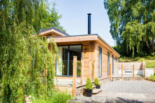 a small wooden cabin with a table and a chair at Willowbeck Lodge Boutique Hotel in Carlisle