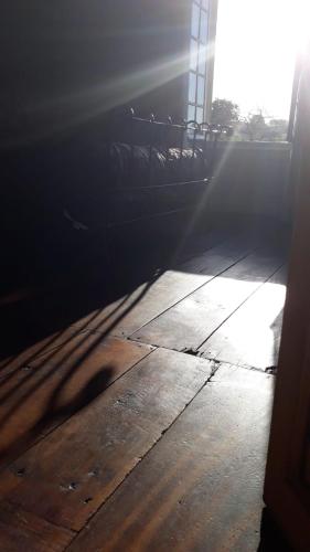 a room with a wooden floor with the sun shining at La Maison du Notaire - Chambre d'Hôtes - Huisdieren welkom in Melay