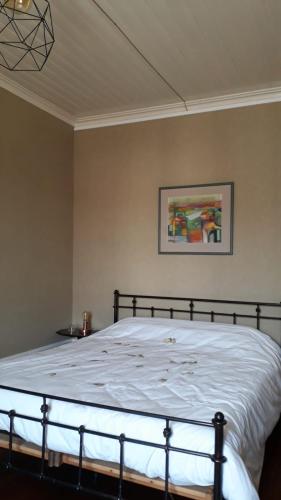 a bed in a bedroom with a picture on the wall at La Maison du Notaire - Chambre d'Hôtes - Huisdieren welkom in Melay