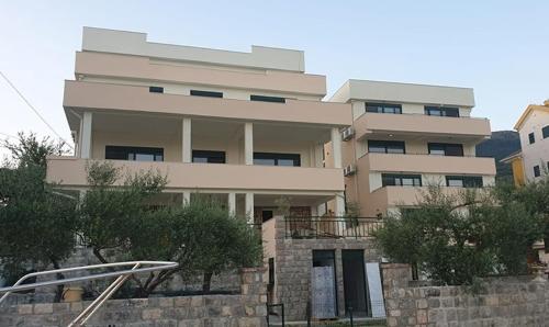 a large white building with trees in front of it at Tondo in Tivat