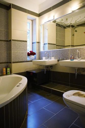 a bathroom with two sinks and a tub and a toilet at Lovely apartm.near airport in Kardiá