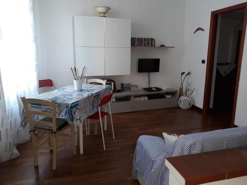 een kamer met een tafel en stoelen en een slaapkamer bij La Giara in La Spezia