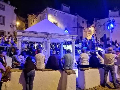 un grupo de personas sentadas alrededor de un cenador por la noche en Casa da Rua Nova, en Castelo de Vide