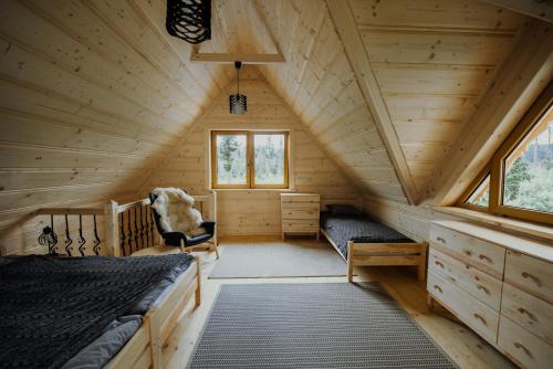 a room with two beds in a wooden cabin at Polanka in Witów