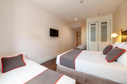 a hotel room with two beds and a tv at Hotel Altora in Tomelloso
